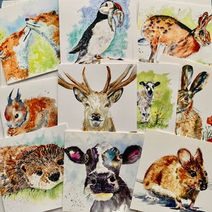 May include: A set of ten watercolour paintings featuring various animals, including a fox, a deer, a cow, a mouse, a rabbit, a bird, and a squirrel. The paintings are all on white cardstock and are framed in simple black frames.
