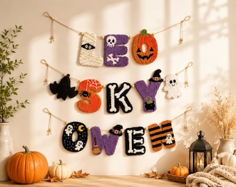 May include: A three-tiered Halloween-themed wall banner featuring tufted fabric letters spelling LEO SKY OWEN. The letters are decorated with motifs including a mummy, skull, pumpkin, spider, ghost, witch hat, cauldron, broom, and bones in orange, purple, black, and white.