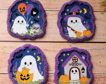 May include: Four punch needle coasters with purple scalloped borders. One shows a ghost with balloons and a RIP tombstone. Another features a ghost with a witch hat and broom. A third depicts a ghost holding a pumpkin. The last shows a ghost in a house with the text BOO.