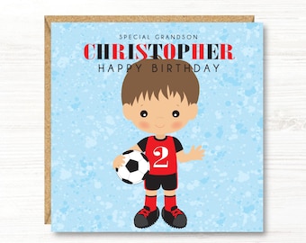 May include: A birthday card featuring a cartoon illustration of a young boy in a soccer uniform holding a soccer ball. The card has the text "SPECIAL GRANDSON CHRISTOPHER HAPPY BIRTHDAY" in red and black lettering against a light blue background.