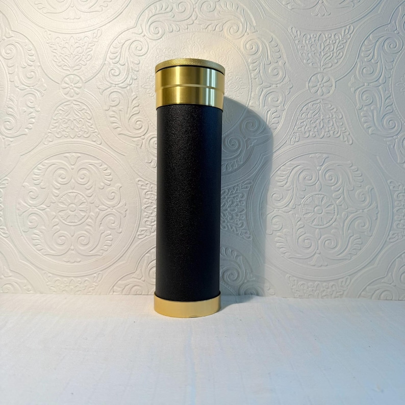 May include: A set of three ceramic mugs with a speckled, matte finish. The mugs are in shades of cream, light gray, and dark gray. Each mug has a simple, minimalist design and a rounded handle.
