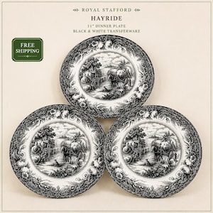 May include: Three 11-inch Royal Stafford Hayride dinner plates featuring black and white transferware. The plates display a detailed rural scene with a horse-drawn cart, figures, and a dog, surrounded by a decorative floral border pattern.