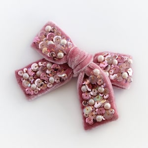 Pink velvet hair bow with sequins and pearls.