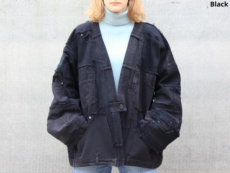 May include: A black denim jacket with a patchwork design. The jacket has a long, open front and a relaxed fit.