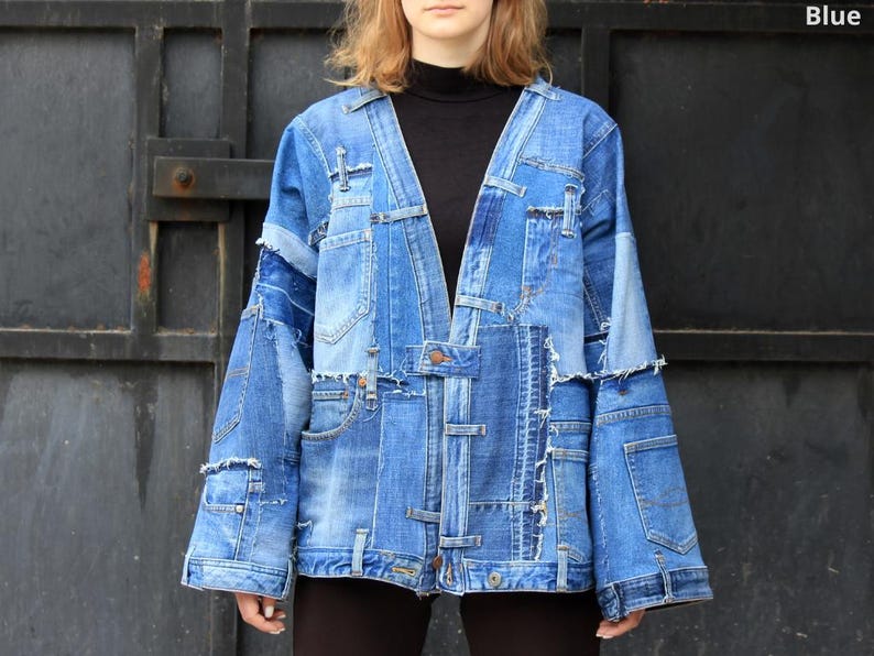 May include: A blue denim jacket with a patchwork design. The jacket has a V-neck and long sleeves. It is made of multiple pieces of denim sewn together.