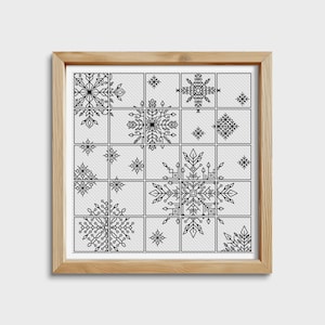 Könnte beinhalten: Ein schwarz-weißes Kreuzstichmuster mit verschiedenen Schneeflocken-Designs in einem Rasterformat. Das Muster ist in einem naturfarbenen Holzrahmen gerahmt.