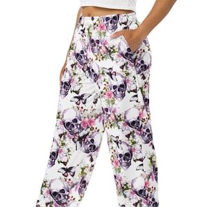May include: White wide-leg pants with a floral and skull print. The pants have an elastic waistband and a relaxed fit.