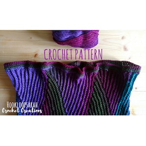 May include: A close-up of a crocheted scarf in shades of purple, green, and teal. The scarf is made with a textured stitch and has a simple, elegant design. The text "CROCHET PATTERN" is visible above the scarf.