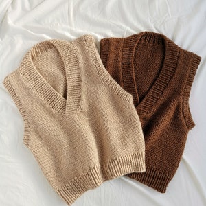 May include: Two knitted sleeveless sweaters, one in beige and one in brown, with a V-neck.
