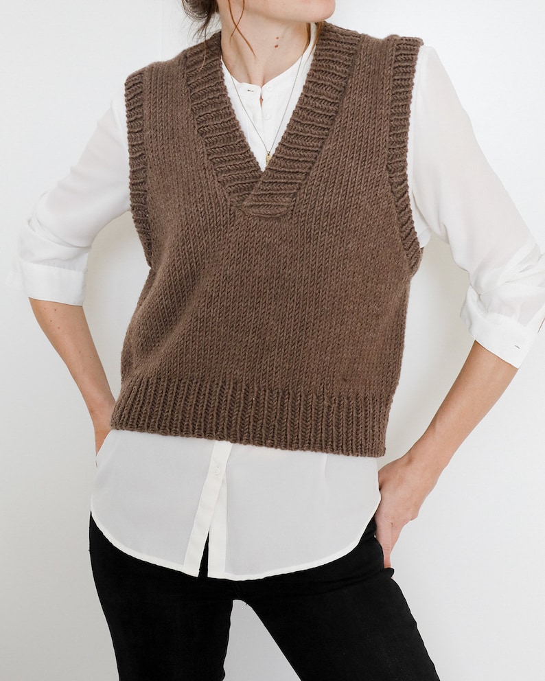 May include: A brown knitted sleeveless sweater vest with a V-neck.