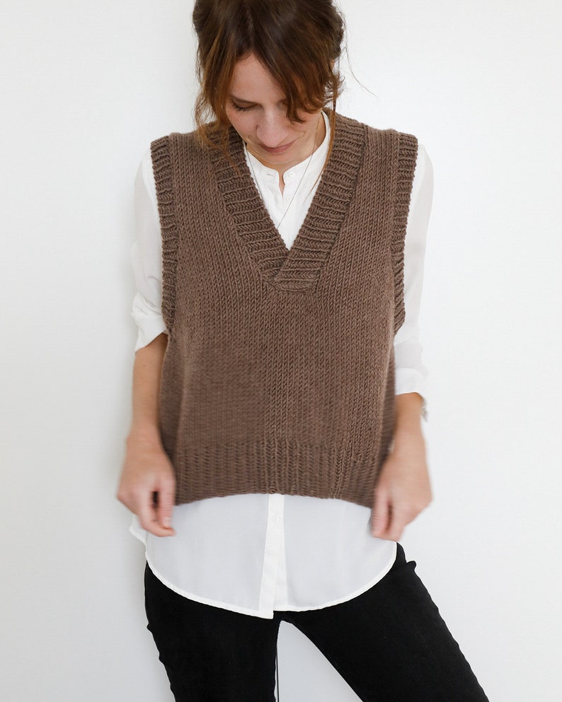May include: A brown knitted sleeveless vest with a V-neck.