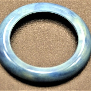 Puede incluir: Un brazalete azul y blanco con un acabado liso y brillante.