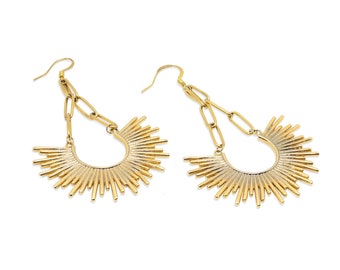 May include: A pair of gold dangle earrings with a sunburst design. The earrings feature a chain link and a circular sunburst with thin, pointed rays.