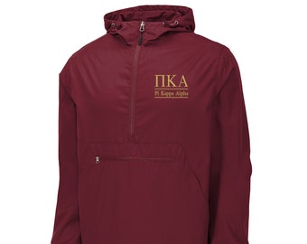 Könnte beinhalten: Burgunderfarbener Kapuzenwindbreaker mit Reißverschluss und Kängurutasche. Die Jacke hat ein golden gesticktes Logo mit der Aufschrift "PKA Pi Kappa Alpha".