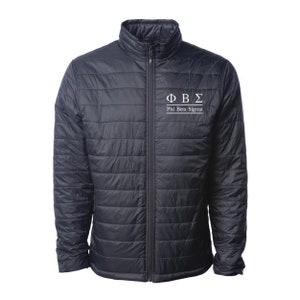 May include: A black quilted jacket with a zipper closure and a white embroidered logo that says "ΦΒΣ Phi Beta Sigma".