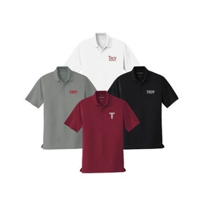 May include: Four polo shirts in different colors: white, gray, maroon, and black. Each shirt has the word "TROY" embroidered on the front in red.