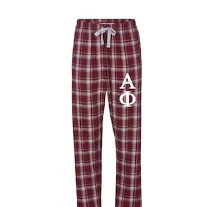 May include: Red and white plaid pajama pants with a white "AΦ" monogram on the left leg.