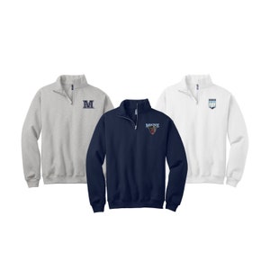 May include: Three quarter-zip sweatshirts in different colors. The gray sweatshirt has a navy blue "M" embroidered on the chest. The navy blue sweatshirt has a bear head with "MAINE" embroidered on the chest. The white sweatshirt has a navy blue "M" with a navy blue and white design embroidered on the chest.