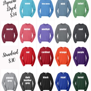 Op de afbeelding: Een tabel met 20 verschillende gekleurde sweatshirts met de woorden "Pigment Dyed $34" en "Standard $30" bovenaan. De sweatshirtkleuren omvatten wave, blue moon, mist, safari, merlot, melon, amethyst, pewter, coal, red, cardinal, orange, purple, athletic grey, dark heather grey, black, royal en forest.