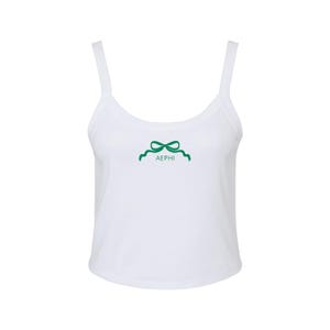 May include: White tank top with a green bow and the letters "AEPHI" printed on the front.