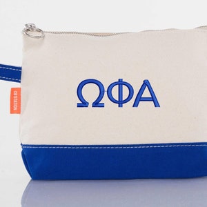 May include: A white canvas zippered pouch with a blue bottom and a blue embroidered "ΩΦΑ" on the front. The pouch has a blue handle and a silver zipper pull.