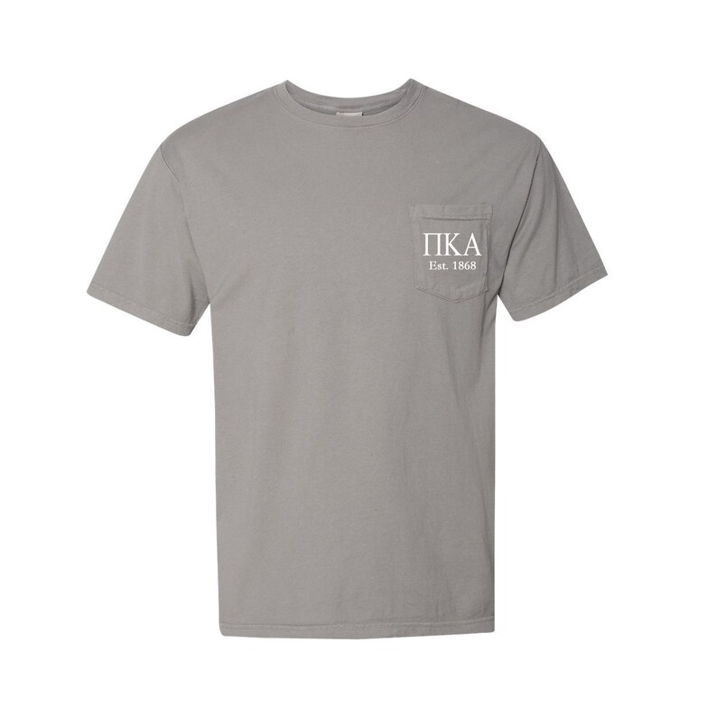 May include: A grey short-sleeved t-shirt with a pocket on the left side. The pocket has the text "PIKA Est. 1868" in white.
