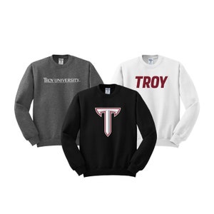 May include: Three sweatshirts in different colors and designs. One is gray with "TROY UNIVERSITY" in white text. Another is white with "TROY" in red text. The last one is black with a large red "T" on the front.
