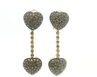 May include: A pair of drop earrings featuring two heart-shaped charms encrusted with small brown stones, connected by a vertical chain of tiny circular links. The metal setting is gold-toned, and the heart charms are covered in pavé-set brown gems.