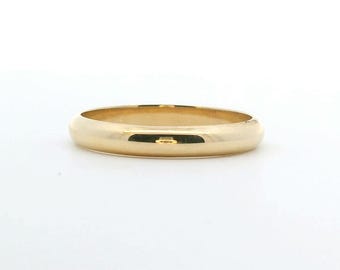 May include: A polished yellow gold band ring with a smooth, rounded surface. The ring features a simple, continuous circular design with a high-shine finish that reflects light across its curved exterior, showcasing a classic and plain metal band.