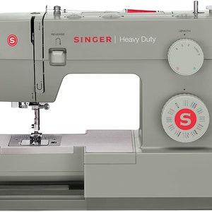 May include: A gray Singer Heavy Duty sewing machine with a white dial for stitch length and a white dial for stitch selection. The machine has a red reverse button and a red Singer logo.