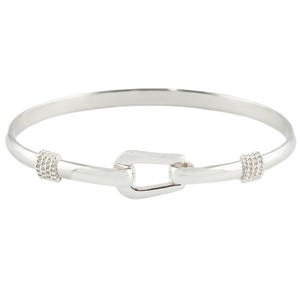May include: A silver-colored bangle bracelet with a hook clasp. The bracelet features a simple, elegant design with a rounded band. The clasp is a rectangular shape. The bracelet has woven detailing on each side of the clasp.