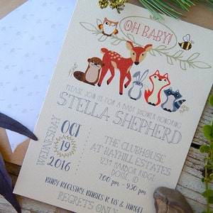 May include: Baby shower invitation featuring woodland animals, including a deer, fox, and raccoon. The invitation reads "Oh Baby!" and includes the date, time, and location for the event. The invitation is printed on cream-colored paper.