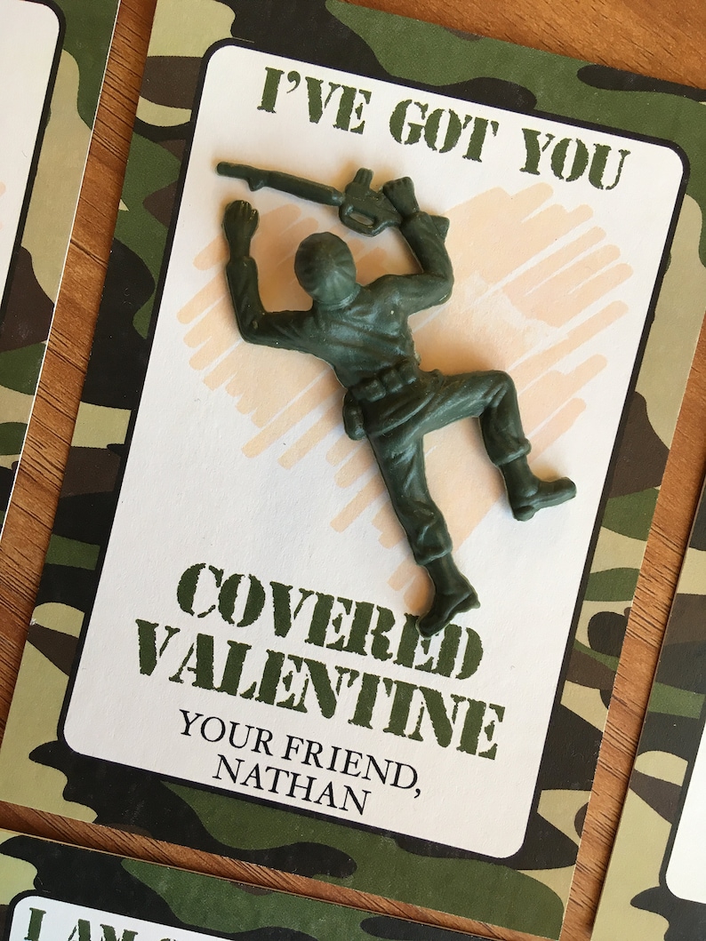 K&ouml;nnte beinhalten: Eine Valentinstagskarte mit einem gr&uuml;nen Spielzeugsoldaten aus Kunststoff. Die Karte hat einen Tarnmuster-Rand und den Text "I've Got You Covered Valentine" und "Your Friend, Nathan."