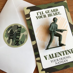 K&ouml;nnte beinhalten: Eine Valentinstagskarte mit einem gr&uuml;nen Spielzeugsoldaten. Die Karte hat ein Tarnmuster und den Text "I'll guard your heart, Valentine, Your friend, Nathan." Ein wei&szlig;er Umschlag und ein "Top Secret"-Aufkleber sind ebenfalls vorhanden.