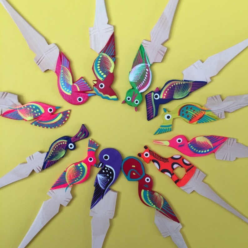 May include: A set of 10 wooden bird ornaments, each painted with bright colors and intricate details. The birds are arranged in a circle on a yellow background.