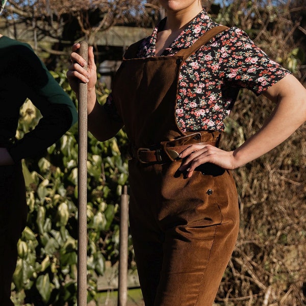 Ladies landgirl trousers, high waist style in brown corduroy, adjust fit via side button fastening, detachable front bib, tapered leg shape.