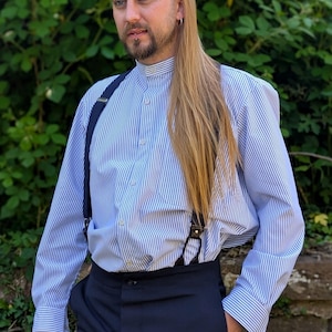 Collarless shirt in heavy cotton ticking, blue and white stripe, button through to hem, front pocket