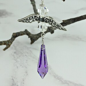 May include: A silver angel charm with crystal wings and a purple crystal teardrop pendant.