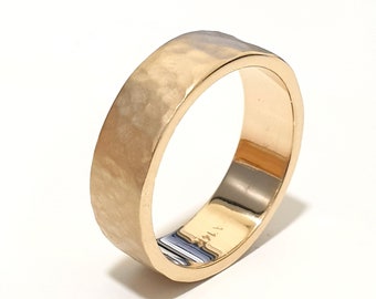 May include: A gold hammered band ring with a smooth, polished interior.