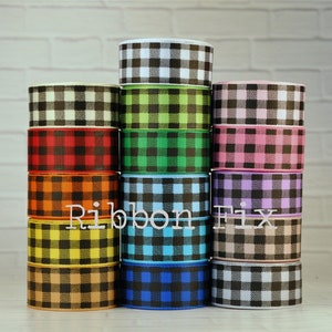 May include: A stack of 12 different colored gingham ribbon rolls. The ribbon is black and white with a variety of colors including red, orange, yellow, green, blue, pink, and purple.
