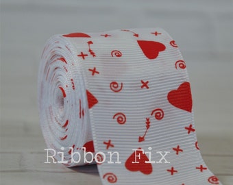 May include: A roll of white ribbon featuring a repeating pattern of red hearts, arrows, swirls, and crosses. The text "Ribbon Fix" is printed on the ribbon. Suitable for crafts and gift wrapping.