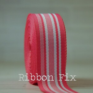 May include: A roll of pink and white striped ribbon. The ribbon is 1 inch wide and has a satin finish.