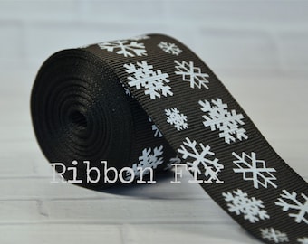 Könnte beinhalten: Schwarzes Band mit weißen Schneeflocken-Designs. Das Band ist aufgerollt und der Text "Ribbon Fix" ist sichtbar.