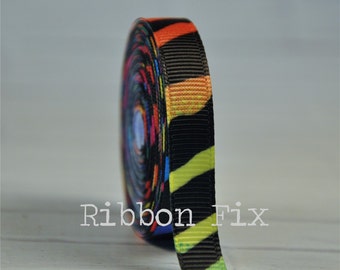 Può includere: Un rotolo di nastro grosgrain colorato con sfondo nero e design a spirale. Il nastro presenta strisce arancioni, gialle, verdi, blu e rosse. Il testo "Ribbon Fix" è visibile sul nastro.
