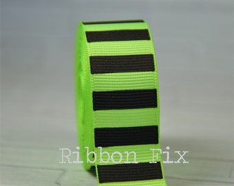 May include: A roll of bright green ribbon with bold black horizontal stripes. The ribbon has a textured surface and the text "Ribbon Fix" is visible on the ribbon.