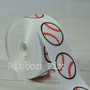 Può includere: Nastro di raso bianco con un motivo ripetuto di palline da baseball rosse e marroni. Il nastro è arrotolato ed è pronto per essere utilizzato per l'artigianato o la decorazione.