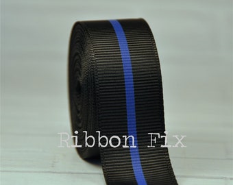 May include: Black grosgrain ribbon with a single blue stripe down the center. The ribbon is rolled up and ready to be used for crafts, gifts, or decorations.