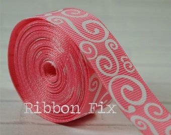 以下が含まれることがあります： 白いスクロールデザインのピンク色のグログランリボンのロール。リボンには「Ribbon Fix」の文字がプリントされています。リボンはきつく巻かれており、質感と模様が示されています。