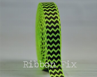 May include: A roll of green and black chevron patterned ribbon. The ribbon is 1 inch wide.