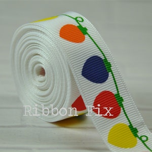 May include: White ribbon with a repeating pattern of colorful light bulbs. The bulbs are red, orange, yellow, blue, and green. The ribbon is rolled up and the text "Ribbon Fix" is visible in the lower left corner.